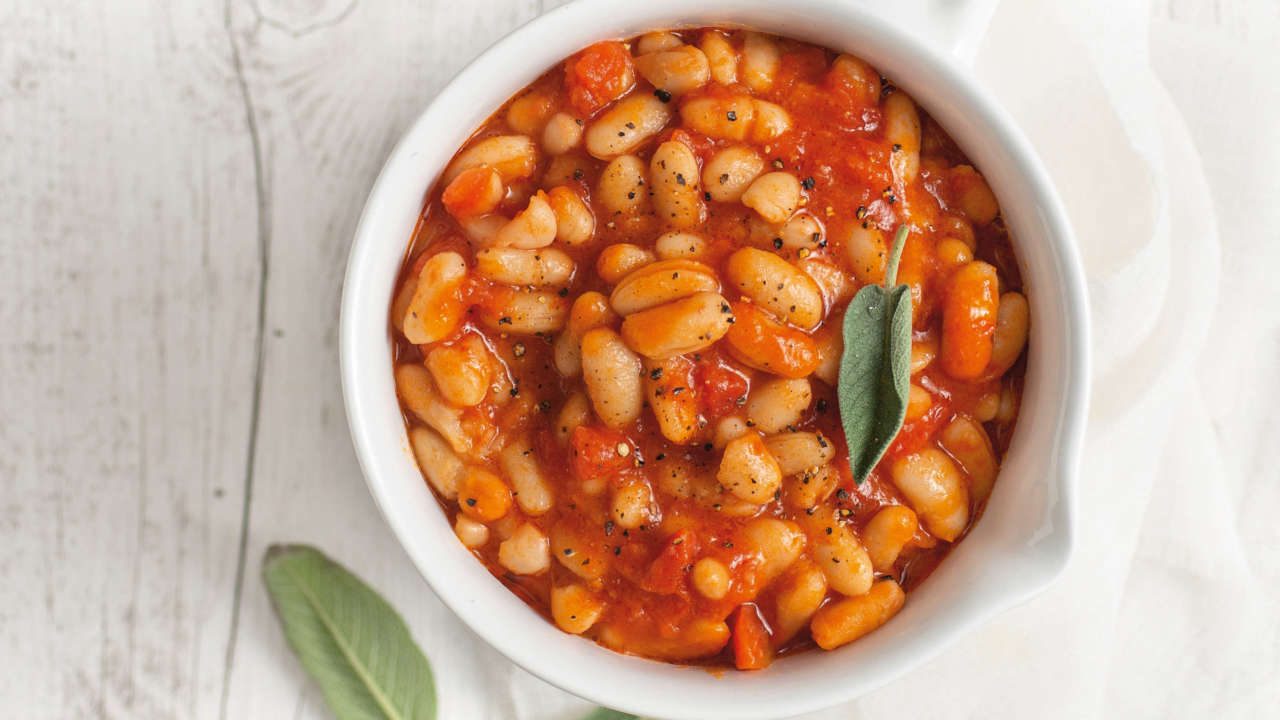 Fagioli all'uccelletto con pomodoro e salvia in un tegamino bianco