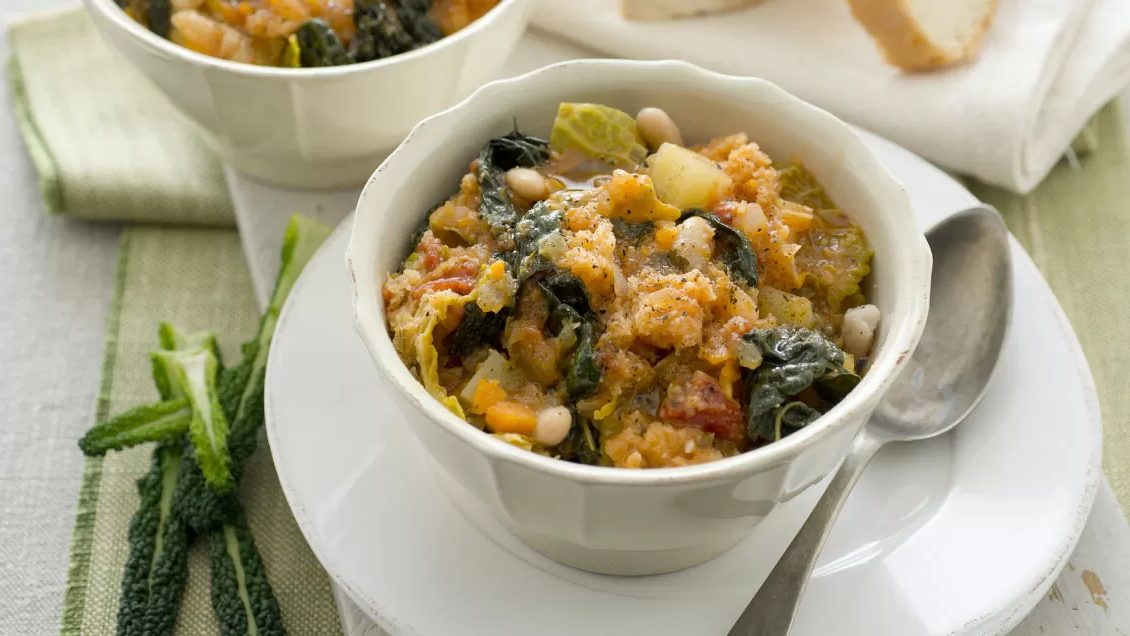 Ribollita toscana con cavolo nero e fagioli cannellini in una ciotola con olio extravergine